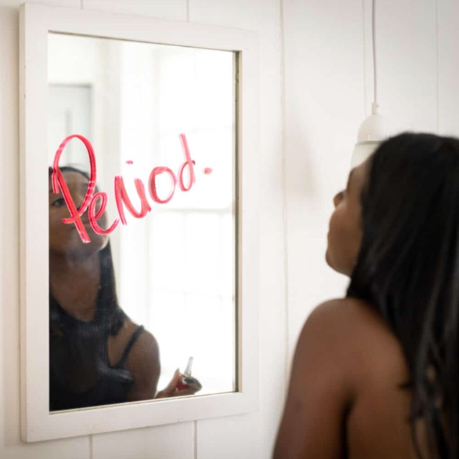 femme face à un miroir avec règles abondantes